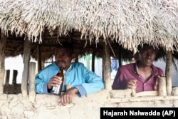 Benson Muhereza enjoys tonto at a local bar in Majengo village, Mbarara, Uganda, Dec. 10, 2023. (AP Photo/Hajarah Nalwadda)