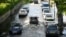 FILE - Cars are driven along a flooded road as the River Thames overtops the riverbank at high tide in London, Britain, April 19, 2023. 