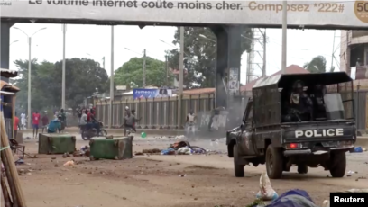 Capture d'écran d'une vidéo d'un manifestant antigouvernemental lançant un objet sur la police à Conakry, Guinée, le 10 mai 2023.