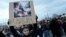 Yon dam kenbe yon pankat ki montre Prezidan Franse Emmanuel Macon ki chita sou yon pil fatra ak pawol "Wa Fatra" pandan yon manifestasyon nan Paris, Vandredi 17 Mas, 2023. 