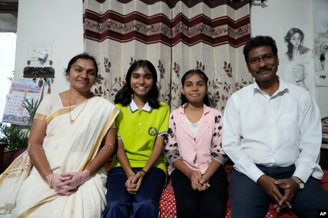 Gautam Dongre sits with his daughters, Sumedha, 13, second right, a patient of sickle cell disease, and Rushali, 15, and his wife, Padmashri, in Nagpur, India, Wednesday, Dec. 6, 2023. (AP Photo/Ajit Solanki)