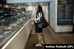 Becky Litvintchouk orders food during her lunch break near her co-working space, on Monday, Aug. 12, in New York. (AP Photo/Andres Kudacki)