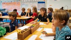 Maui Preparatory Academy students listen during an English lesson, in Lahaina, Hawaii, Oct. 3, 2023. Three public schools that survived a wildfire in Lahaina more than two moths ago are set to reopen Monday.