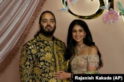 Anant Ambani, left, and Radhika Merchant pose for photographers during their pre-wedding ceremony in Mumbai, India, Friday, July 5, 2024. (AP Photo/Rajanish Kakade, File)