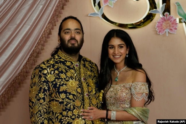 Anant Ambani, left, and Radhika Merchant pose for photographers during their pre-wedding ceremony in Mumbai, India, Friday, July 5, 2024. (AP Photo/Rajanish Kakade, File)