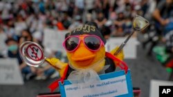 FILE - A yellow toy duck, with a message attached during a rally in Bangkok, Thailand, March 24, 2021, ahead of an indictment against 13 protest leaders on for allegations of sedition and defaming the monarchy.