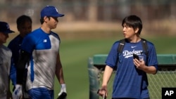 FILE - The Los Angeles Dodgers' Shohei Ohtani, left, walks with interpreter Ippei Mizuhara a during spring training baseball workout in Phoenix, Arizona, Feb. 12, 2024. On Friday, a judge released Mizuhara on $25,000 bond and mandated he undergo treatment for gambling addiction. 