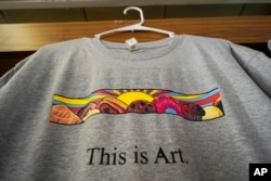 A T-shirt showing the painting displayed outside Leavitt's Country Bakery, is displayed Thursday, April 13, 2023, in Conway, N.H. (AP Photo/Robert F. Bukaty)