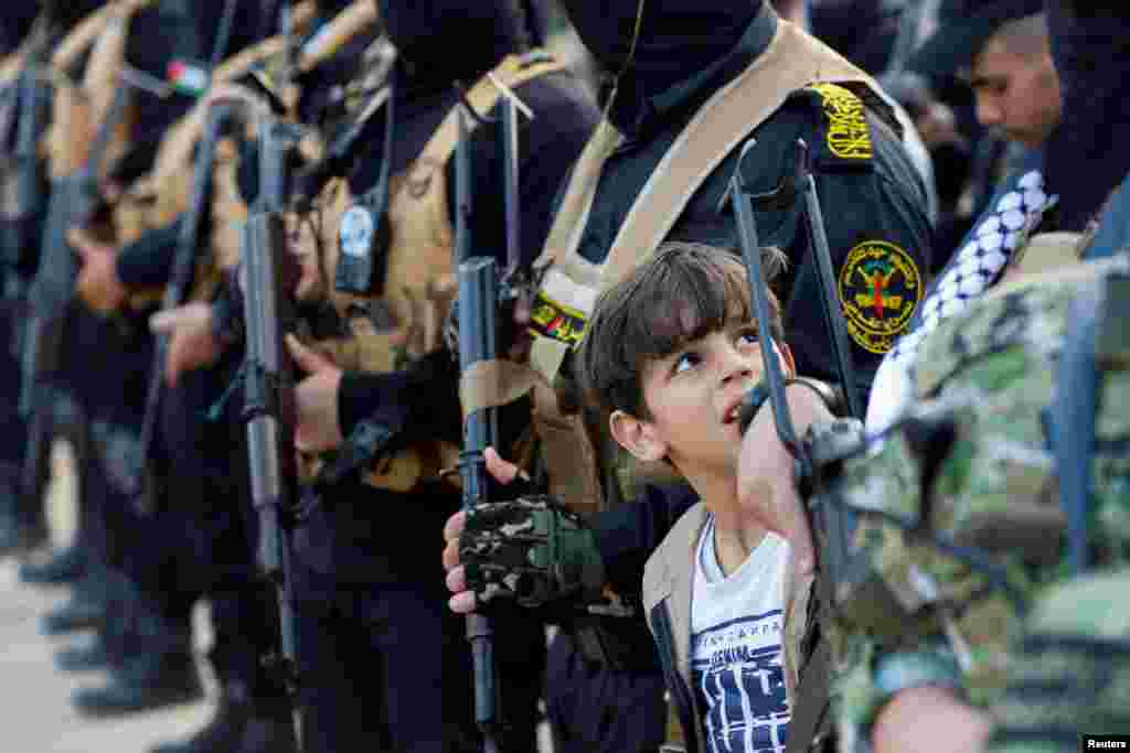 A child looks on as the Palestinian Islamic Jihad group holds a rally in Gaza to commemorate armed commanders and operatives killed by Israel in the past five-day fighting, in Gaza City.