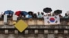 Spectators with a flag of South Korea look on from a Paris bridge to watch the floating parade on the river Seine during the Olympic Games opening ceremony, July 26, 2024.