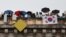 Spectators with a flag of South Korea look on from a Paris bridge to watch the floating parade on the river Seine during the Olympic Games opening ceremony, July 26, 2024.