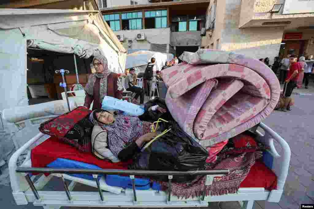 A woman lies down as Palestinian patients fearing an Israeli ground operation,flee Al-Aqsa Martyrs hospital after Israeli army ordered the evacuation of nearby areas, in Deir Al-Balah in the central Gaza Strip, Aug. 25, 2024.