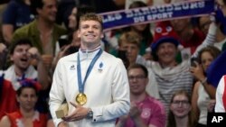 Leon Marchand, of France, reacts as he stands on the podium after receiving his gold medal for the men's 200-meter individual medley final at the 2024 Summer Olympics, in Nanterre, France, Aug. 2, 2024.