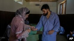 A staff member of a mental health hospital hands medicines to a patient in Srinagar, Indian-controlled Kashmir, on Aug 1, 2023.