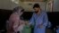 A staff member of a mental health hospital hands medicines to a patient in Srinagar, Indian-controlled Kashmir, on Aug 1, 2023.