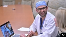 FILE - Dr. Rohaid Ali plays a video from a high school project made by his patient Alexis Bogan on March 11, 2024, at Rhode Island Hospital in Providence, R.I.