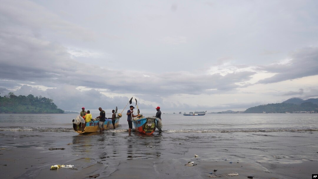 FILE - Local Cameroonian fishermen prepare fishing nets on their boats along the shores of Limbe beach, Cameroon, Apr. 12, 2022. Fishing and tourism have been temporarily suspended in coastal town of Kribi because of damage caused by ocean waters sweeping through the area.