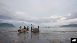 FILE - Local Cameroonian fishermen prepare fishing nets on their boats along the shores of Limbe beach, Cameroon, Apr. 12, 2022. Fishing and tourism have been temporarily suspended in coastal town of Kribi because of damage caused by ocean waters sweeping through the area.