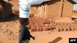 FILE: A refugee walks past drying bricks in the Dzaleka Refugee camp on World Refugee Day in Dowa District Central region of Malawi. Taken June 20, 2018.