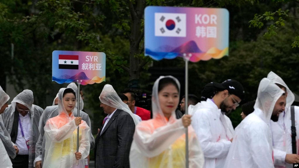 Volunteers hold country signs during team welcoming ceremony at the 19th Asian Games in Hangzhou, China, Sept. 21, 2023