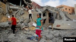 Anak-anak Palestina memeriksa sebuah rumah di Rafah, selatan Jalur Gaza, yang terkena serangan Israel, di tengah konflik yang sedang berlangsung antara Israel dan Hamas, 5 Mei 2024. (REUTERS/Hatem Khaled)