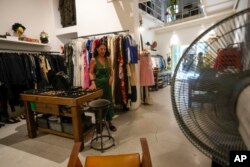 Floriana Peroni walks in her vintage clothing store in downtown Rome, that was forced to shut down for a week by a truck of rented generators blocking her door, in Rome, July 25, 2023.