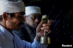 Seorang pendeta Hindu Tengger memimpin doa saat Mendhak Tirta, sebuah ritual penyucian untuk mengambil air suci dari gua Widodaren, menjelang festival Yadnya Kasada, di Taman Nasional Bromo Tengger Semeru di Pasuruan, Jawa Timur, 19 Juni 2024. (REUTERS/Willy Kurniawan)