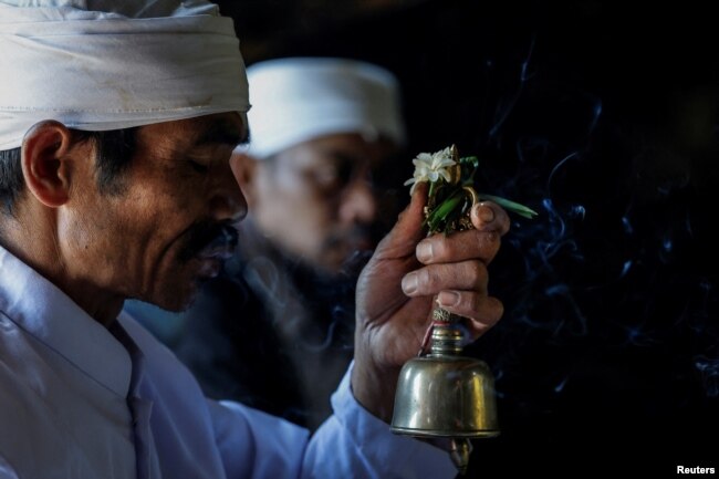 Seorang pendeta Hindu Tengger memimpin doa saat Mendhak Tirta, sebuah ritual penyucian untuk mengambil air suci dari gua Widodaren, menjelang festival Yadnya Kasada, di Taman Nasional Bromo Tengger Semeru di Pasuruan, Jawa Timur, 19 Juni 2024. (REUTERS/Willy Kurniawan)