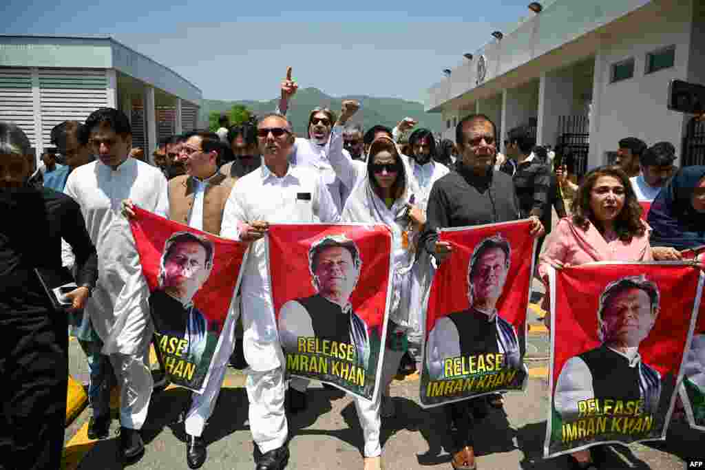 Anggota parlemen dari partai Pakistan Tehreek-e-Insaf (PTI) membawa poster mantan PM Pakistan yang dipenjara Imran Khan, selama aksi protes di luar gedung Parlemen di Islamabad. (AFP)&nbsp;