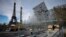 FILE - Workers build the stands for the upcoming Olympic Games on the Champ-de-Mars just beside the Eiffel Tower, in Paris, April 1, 2024 in Paris. 