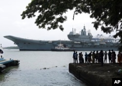 FILE - People watch the INS Vikrant leave for trials in the Arabian Sea in Kochi, India, July 2, 2022.