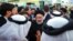 A handout picture provided by the Iranian presidency on May 4, 2023, shows Iranian President Ebrahim Raisi, center, surrounded by people during his visit to the holy shrine of Sayyida Zaynab in the southern suburbs of Damascus, Syria.