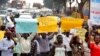 ARCHIVES - Des militants anti-homosexuels défilent dans les rues de Kampala en portant des pancartes le 11 août 2014. 