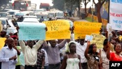 ARCHIVES - Des militants anti-homosexuels défilent dans les rues de Kampala en portant des pancartes le 11 août 2014. 