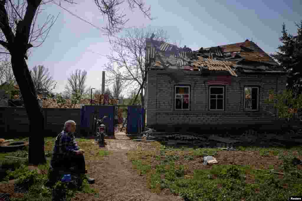 Un local se sienta frente a la casa de su hijo que fue gravemente dañada por un ataque aéreo, el 10 de abril de 2024.&nbsp;