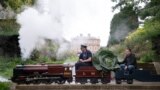 Steam engine driver Bob Corrie, left, and grower Paul Proud transport Proud's cabbage that won its category in the giant vegetable competition at the Harrogate Autumn Flower Show held at Newby Hall country house, near Ripon, northern England.