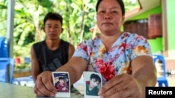 The parents of Natthaporn, who was working in Israel and has been abducted in the ongoing conflict between Israel and the Palestinian Islamist group Hamas, hold up his pictures at their house in Nakhon Phanom, Thailand, Oct. 10, 2023. 