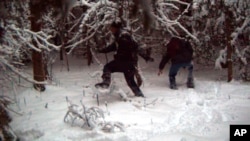 FILE - This surveillance image shows two individuals illegally crossing the U.S.-Canada border in January 2023 at the Vermont-New Hampshire-New York enforcement sector. Federal authorities have added 25 border patrol agents at a section of the northeastern U.S. border with Quebec in response to a spike in illegal crossings. The team started March 6, 2023.