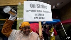 Teacher Sarah Harris joins Los Angeles Unified School District, LAUSD teachers and Service Employees International Union 99 members striking as rain falls outside the Edward R. Roybal Learning Center in Los Angeles, March 21, 2023. 