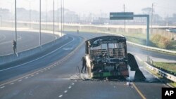A burned-out bus stands on a freeway on the outskirts of Cape Town, South Africa, Aug. 7, 2023. Two people were fatally shot on a fifth day of violent protests sparked by a dispute between minibus taxi drivers and authorities. 