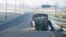 A burned-out bus stands on a freeway on the outskirts of Cape Town, South Africa, Aug. 7, 2023. Two people were fatally shot on a fifth day of violent protests sparked by a dispute between minibus taxi drivers and authorities. 