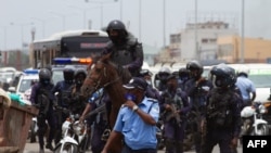 FILE - Angolan police officers look on in Luanda on Feb. 4, 2021 during a demonstration against police brutality, days after several separatists were killed in a thwarted protest in the country's northeast. 
