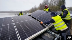 FILE - Solar panels are installed on a lake in Haltern, Germany, Friday, April 1, 2022. Floating solar panel farms are attractive not just for their clean power and lack of a land footprint, but because they also conserve water by preventing evaporation. (AP Photo/Martin Meissner, File)
