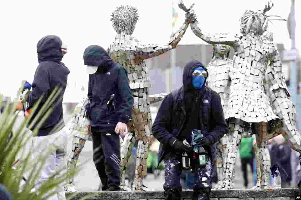 Маскирани млади со молотови коктели се гледаат како републикански демонстранти кои се противат на мировниот договор склучен Велики петок во 1998 година, во Лондондери, Северна Ирска.