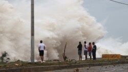 Orang-orang berdiri di pantai menghadap terjangan ombak, saat Badai Beryl bergerak ke selatan pulau, di Santo Domingo, Republik Dominika, 2 Juli 2024. (REUTERS/Erika Santelices)