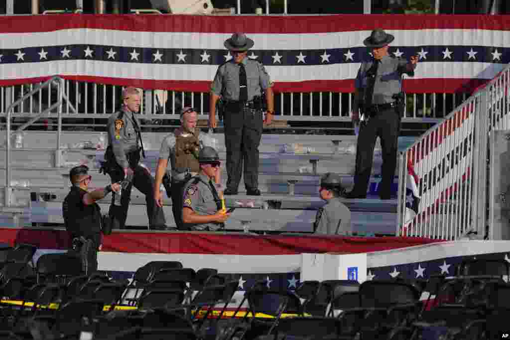 Law enforcement officers gather at the campaign rally site.