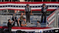 FILE - Law enforcement officers gather at the campaign rally site for Republican presidential candidate former President Donald Trump, July 13, 2024, in Butler, Pa.