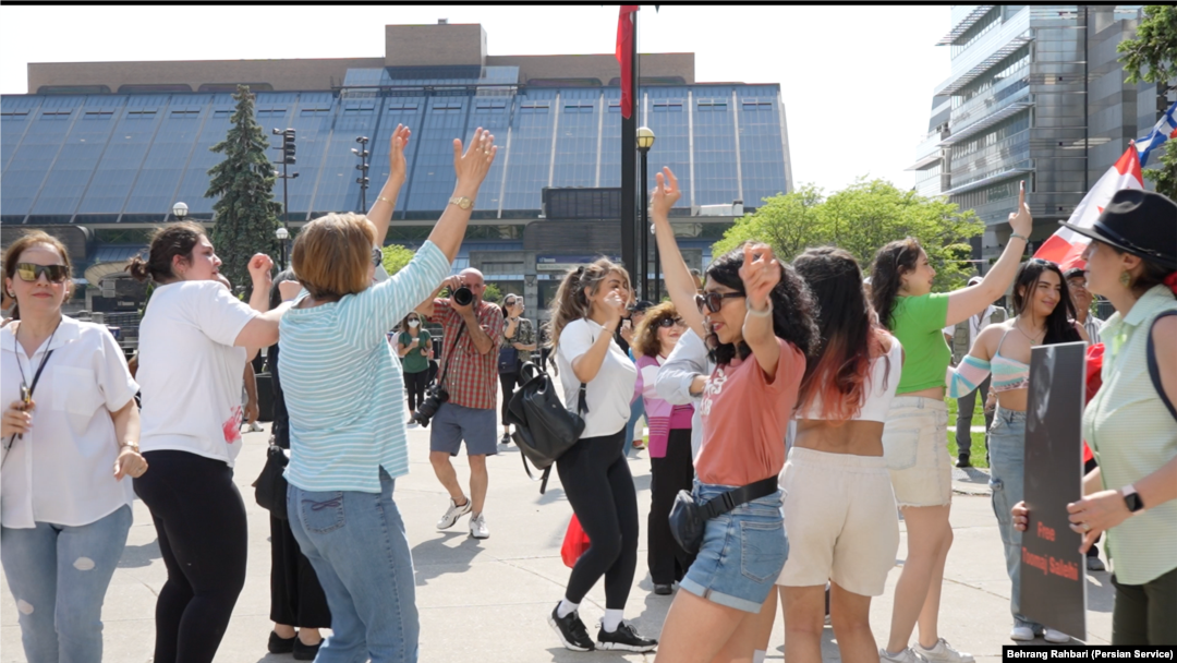 Iranians dance in Toronto, Canada, on May 20, 2024, to celebrate the death a day earlier of Iranian President Ebrahim Raisi, who was reviled by opponents of Iran's authoritarian Islamist rulers. (Behrang Rahbari/VOA Persian)