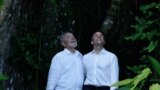 Presiden Brazil Luiz Inacio Lula da Silva dan Presiden Prancis Emmanuel Macron melihat kanopi pohon yang di Pulau Combu di dekat Belem, Brazil, pada 26 Maret 2024. (Foto: Reuters/Ueslei Marcelino)