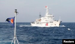 Bendera Vietnam Marine Guard berkibar di dekat kapal Coast Guard China di Laut China Selatan, sekitar 210 km lepas pantai Vietnam, 14 Mei 2014. (Foto: Reuters)